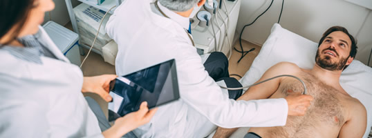 Doctors performing an Echocardiogram on male patient